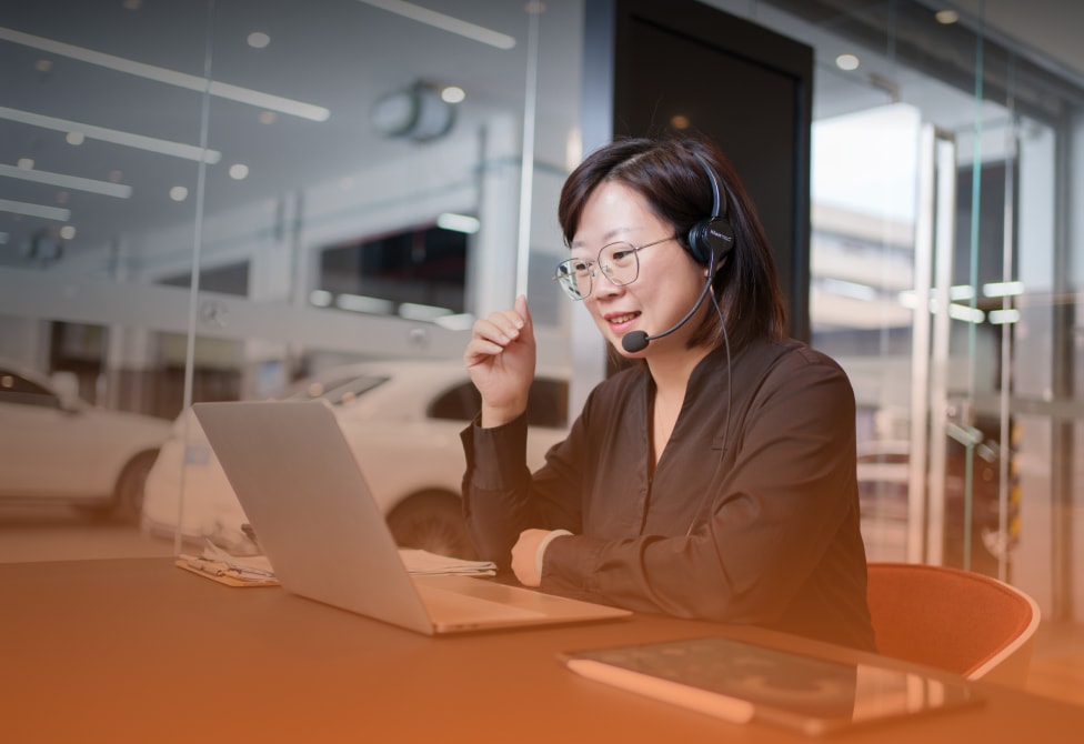 Woman with headset in a meeting in front of a laptop
