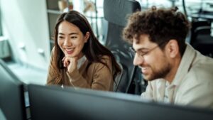 Two individuals gaze at a computer screen