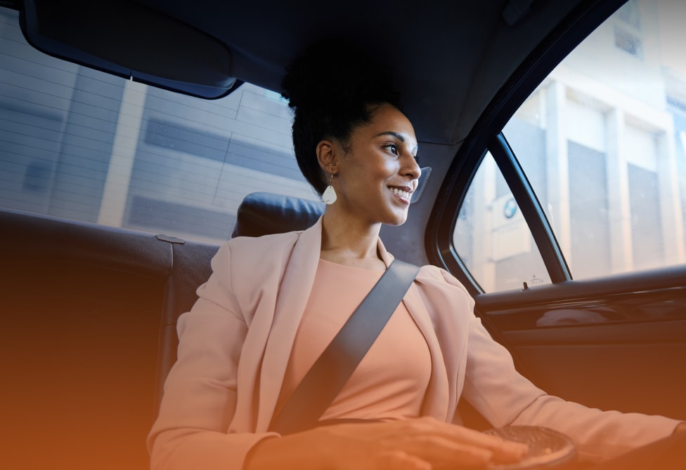 Smiling businesswoman looking at the city from the back seat of taxi