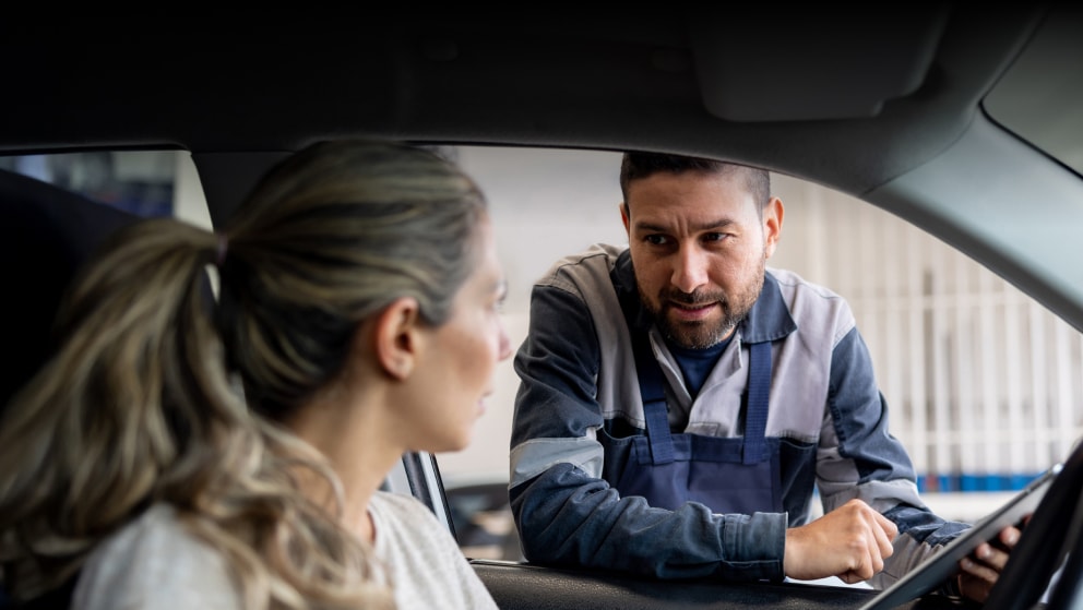 Mechanic explaining to a woman the diagnosis on her car