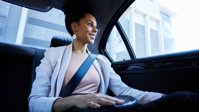 Smiling businesswoman looking at the city from the back seat of taxi
