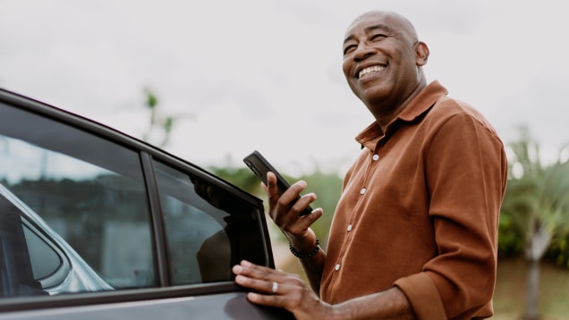 Man getting into a Uber holding smartphone