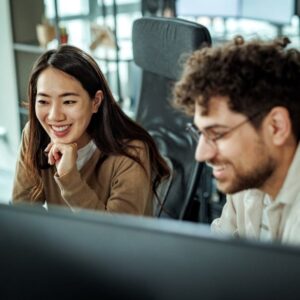 Two individuals gaze at a computer screen
